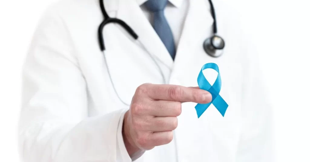 Lekarz trzyma w dłoni niebieską wstążkę - symbol świadomości raka prostaty