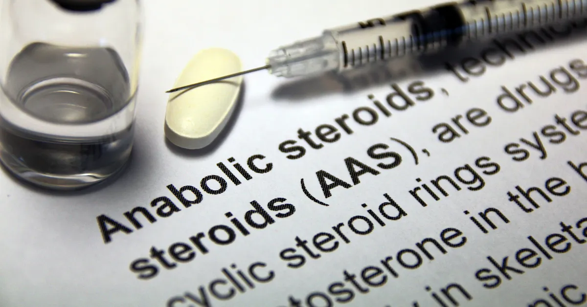 Strzykawka oraz napis "Anabolic steroids" - nawiązanie do tematu artykułu o róznicach między TRT a dopingiem