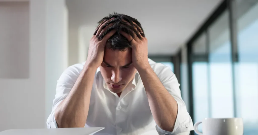 Zestresowany i senny mężczyzna próbuje się skupić na pracy