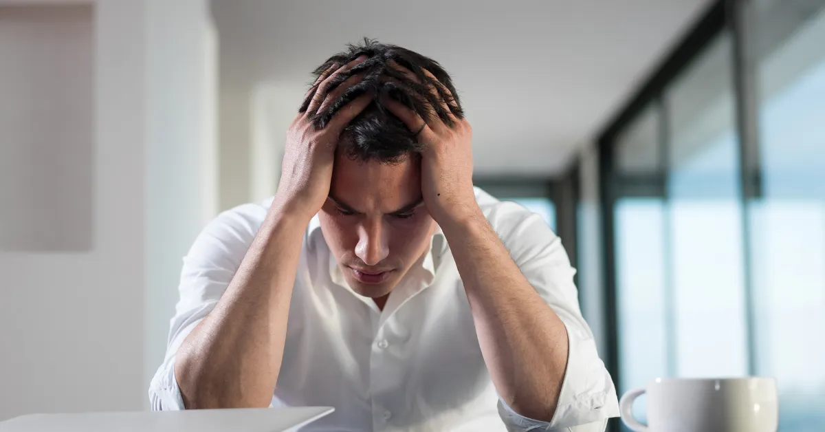 Zestresowany i senny mężczyzna próbuje się skupić na pracy